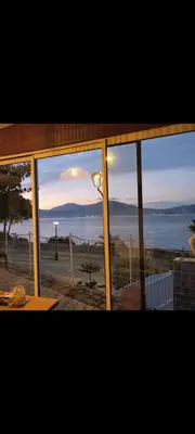 a view of the ocean from a glass window at CHALET de la plage in Porticcio