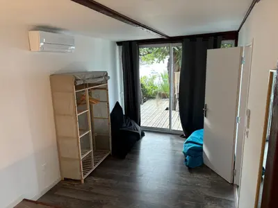 a room with a refrigerator and a door to a patio at CHALET de la plage in Porticcio