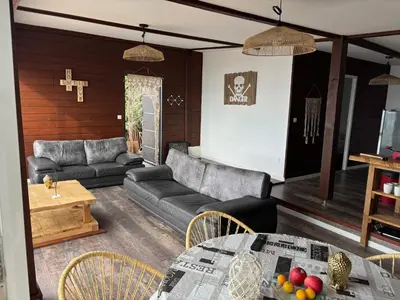 a living room with a couch and a table at CHALET de la plage in Porticcio