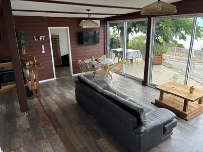 a living room with a couch and a table at CHALET de la plage in Porticcio