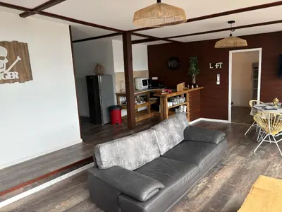 a living room with a couch and a kitchen at CHALET de la plage in Porticcio