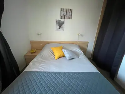 a bedroom with a bed with a yellow pillow at Appartement Jardin de la Mer in Linguizzetta