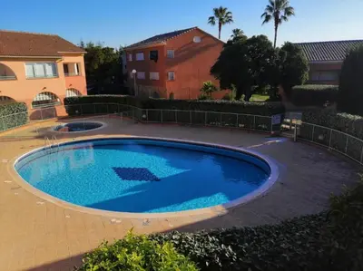 a large blue swimming pool in front of a house at Appartement Jardin de la Mer in Linguizzetta