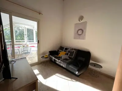 a living room with a couch in the corner at Appartement Jardin de la Mer in Linguizzetta