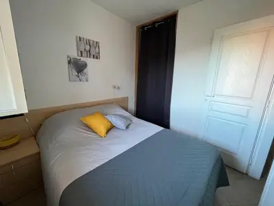a bedroom with a bed with a yellow pillow at Appartement Jardin de la Mer in Linguizzetta