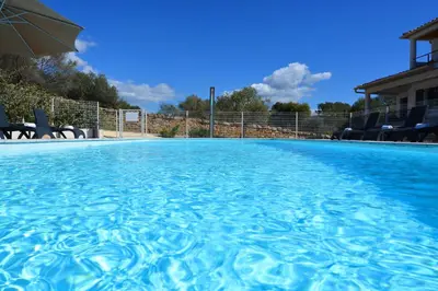 a large swimming pool with an umbrella and chairs at Les Terrasses Du Grand Large in Porto Pollo