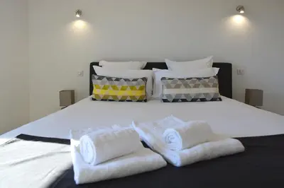 a bed with white towels and pillows on it at Les Terrasses Du Grand Large in Porto Pollo