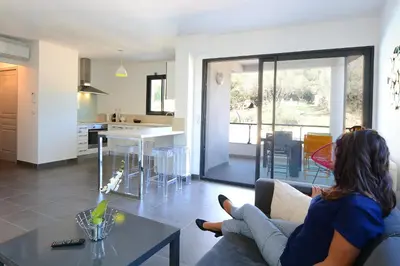 a woman sitting on a couch in a living room at Les Terrasses Du Grand Large in Porto Pollo