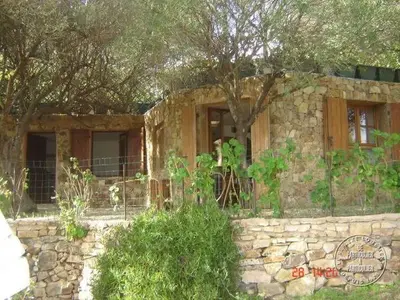 a stone house with a tree in front of it at Villa Pierre Vergerie in Cargèse