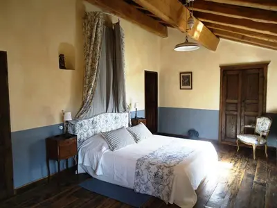 a bedroom with a white bed and a chair at Le Hameau de Saparale in Sartène