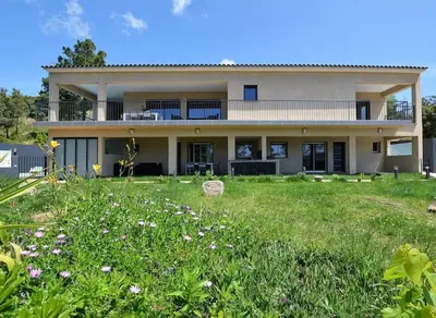 a large house with a grass field in front of it at CasaNota Haut de villa 200m2 avec piscine privée in Porto-Vecchio