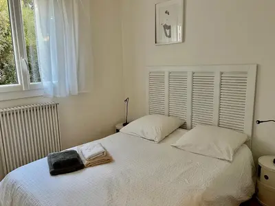 a bedroom with a white bed and a window at Villa Nausicaa in Pietrosella