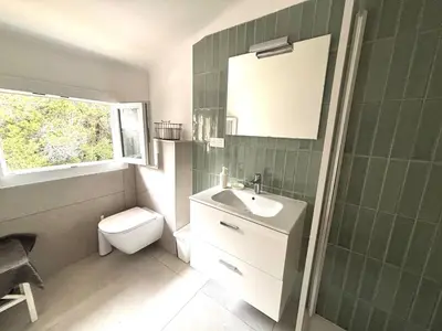 a bathroom with a sink and a toilet and a window at Villa Nausicaa in Pietrosella
