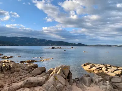 a large body of water with rocks in the water at Villa Nausicaa in Pietrosella