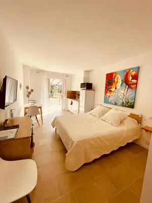 a bedroom with a bed and a table and a desk at Patios di Pruno Studio NINO in Figari