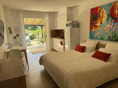 a bedroom with a bed and a kitchen with a refrigerator at Patios di Pruno Studio NINO in Figari