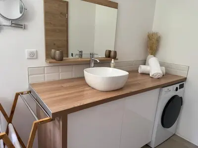 a bathroom with a sink and a washing machine at Patios di Pruno Studio NINO in Figari