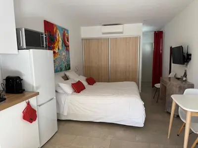 a bedroom with a white bed and a refrigerator at Patios di Pruno Studio NINO in Figari