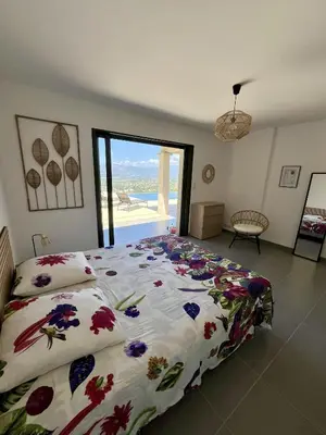 a bedroom with a bed with a floral comforter at Villa de Luxe avec Piscine à débordement chauffée à Porticcio in Porticcio