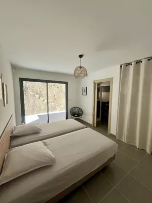 a bedroom with two beds and a large window at Villa de Luxe avec Piscine à débordement chauffée à Porticcio in Porticcio