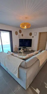 a large couch in a living room with a television at Villa de Luxe avec Piscine à débordement chauffée à Porticcio in Porticcio