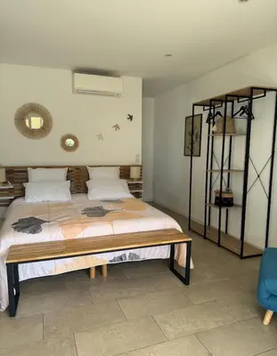 a bedroom with a bed and a blue chair at Patios di pruno Suite MELO in Figari