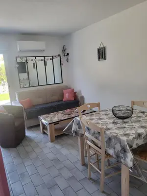a living room with a table and a couch at Porto Vecchio - Résidence RIVIERA- Villa Lecci in Lecci