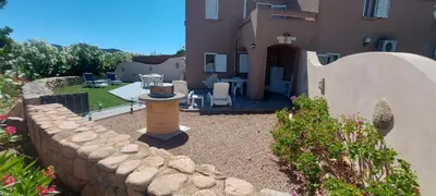 a stone retaining wall next to a house with a patio at Porto Vecchio - Résidence RIVIERA- Villa Lecci in Lecci