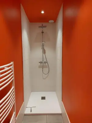 a shower in a bathroom with an orange wall at Porto-Vecchio - Lecci Lodge in Lecci