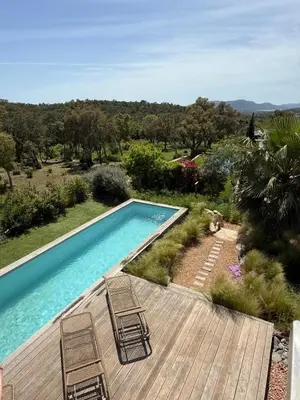 a swimming pool with chairs next to a wooden deck at Porto-Vecchio - Lecci Lodge in Lecci