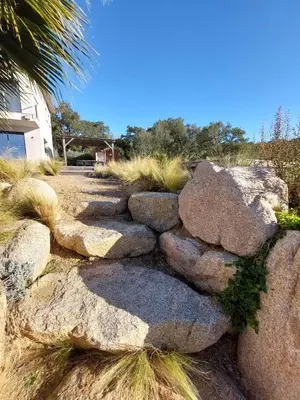 a stone retaining wall with some plants at Porto-Vecchio - Lecci Lodge in Lecci