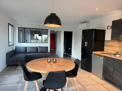 a kitchen and living room with a table and chairs at Porto-Vecchio - Lecci Lodge in Lecci