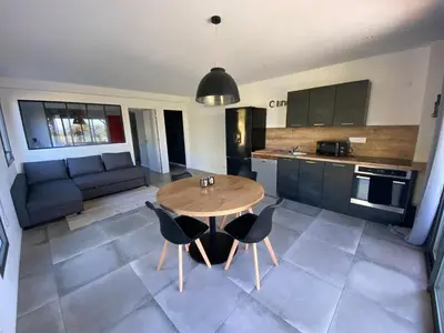 a kitchen and living room with a table and chairs at Porto-Vecchio - Lecci Lodge in Lecci