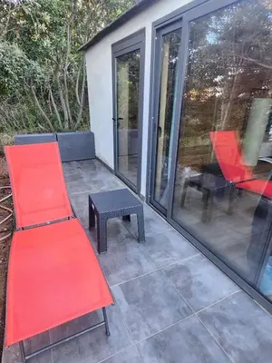 a patio with a red bench and a table at Crique privée in Conca