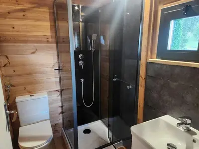 a bathroom with a shower and a toilet and a sink at Crique privée in Conca