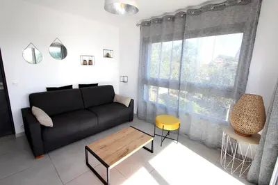 a living room with a black couch and a table at T2 centre-ville de Porto-Vecchio in Porto-Vecchio