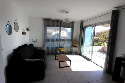 a living room with a couch and a large window at T2 centre-ville de Porto-Vecchio in Porto-Vecchio