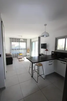 a kitchen with a table and chairs in a room at T2 centre-ville de Porto-Vecchio in Porto-Vecchio