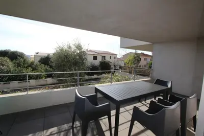 a balcony with a table and chairs on a roof at T2 centre-ville de Porto-Vecchio in Porto-Vecchio