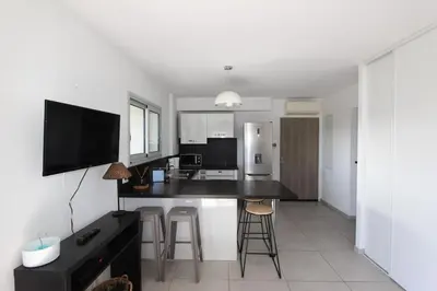 a kitchen with a black counter top in a room at T2 centre-ville de Porto-Vecchio in Porto-Vecchio