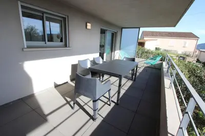 a patio with a table and chairs on a balcony at T2 centre-ville de Porto-Vecchio in Porto-Vecchio
