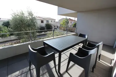 a table and chairs on a balcony with a view at T2 centre-ville de Porto-Vecchio in Porto-Vecchio