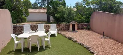 a group of white chairs and a table in a yard at Porto Vecchio - Résidence RIVIERA- Villa Bonifacio in Lecci
