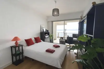 a bedroom with a white bed with red pillows on it at Beautiful T4 apt with a view of the Gulf d'Ajaccio in Ajaccio