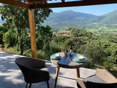 a table and chairs on a patio with a view at Casa Lisandru- Mini-Villa proche des plages in Viggianello