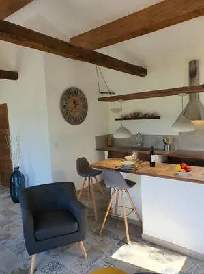 a kitchen with a counter and a clock on the wall at Casa Lisandru- Mini-Villa proche des plages in Viggianello