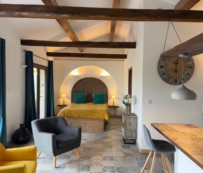 a bedroom with a bed and a clock on the wall at Casa Lisandru- Mini-Villa proche des plages in Viggianello