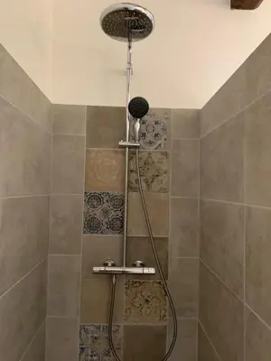 a shower with a shower head in a bathroom at Casa Lisandru- Mini-Villa proche des plages in Viggianello