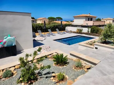 a backyard with a pool and chairs and a house at Villa DIMA - piscine chauffée climatisation barbecue pétanque in Calenzana