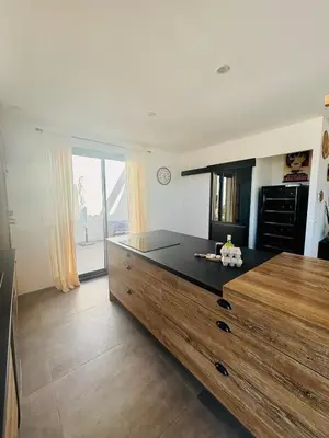 a kitchen with a large dresser with a black counter top at Villa DIMA - piscine chauffée climatisation barbecue pétanque in Calenzana